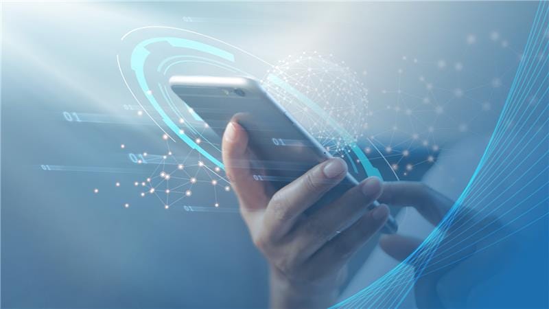 Smartfon w dłoni z wizualizacją sieci danych, symbol cyfrowej transformacji, technologii IT i przepływu informacji. Grafika do sekcji usług IT lub innowacji technologicznych.