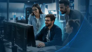 Software development team collaborating at a workstation while onboarding an external IT specialist into the project.